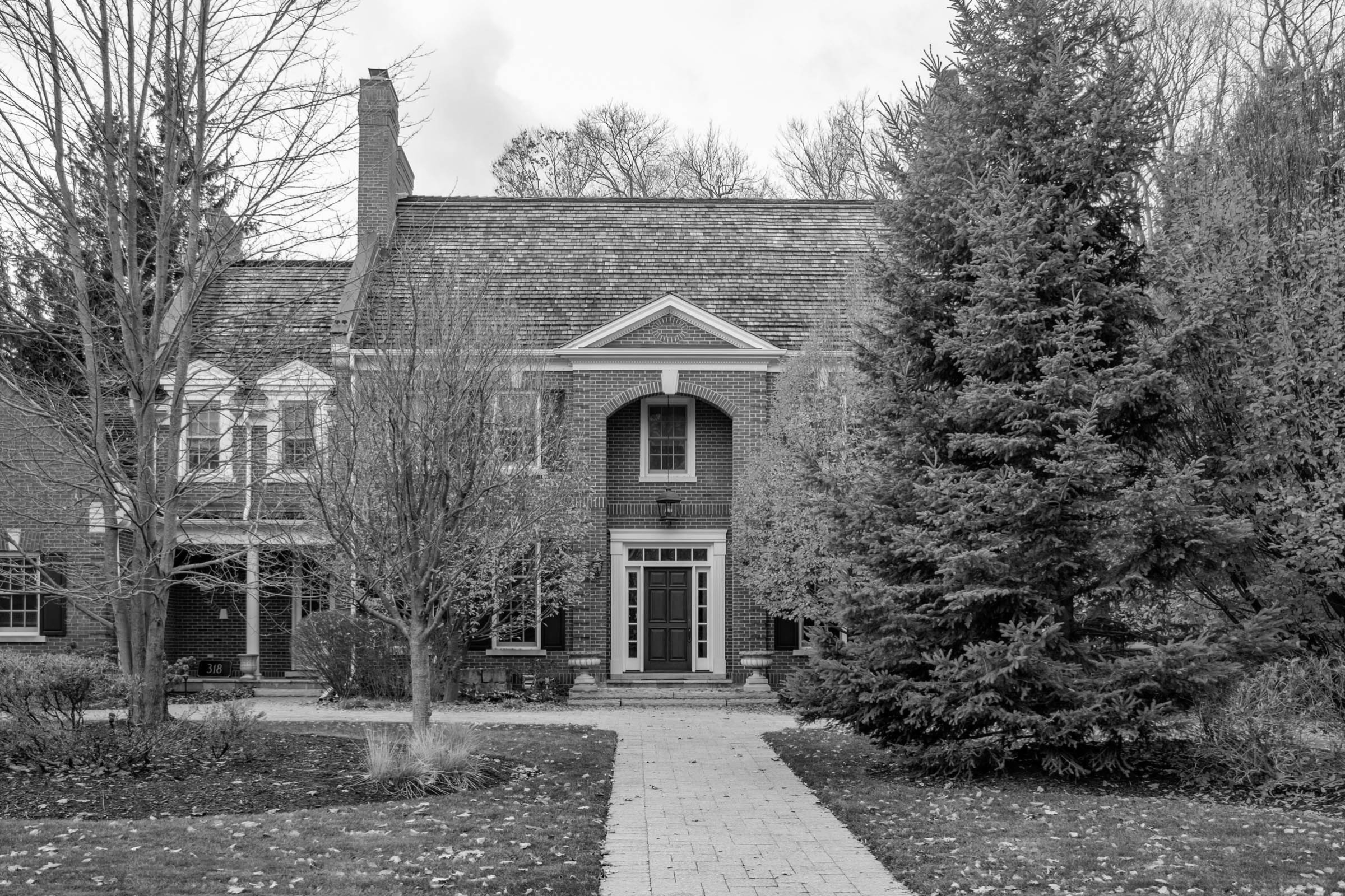 large estate home with trees in front located in the Colonial Acres neighbourhood of East Waterloo, Ontario
