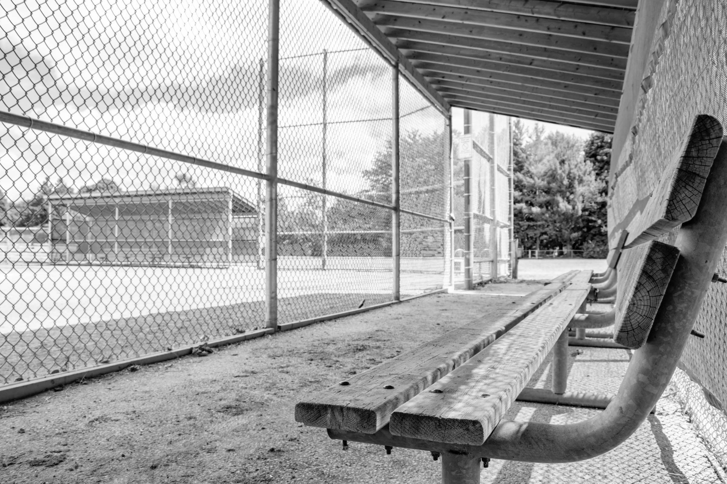 a photo of a bench in the dugout at a baseball diamond in the Lincoln Village area of Waterloo, Ontario