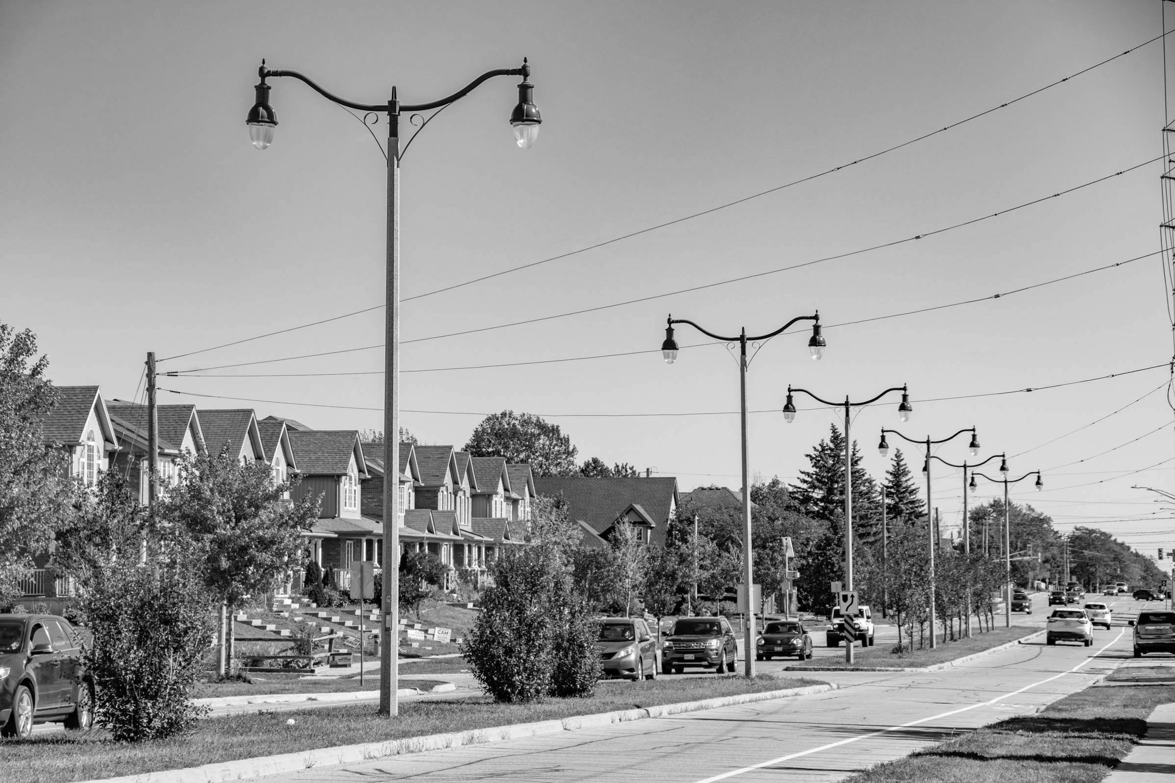 homes and street lights lining the street with cars. Located in the Country Club neighbourhood in North Guelph, Ontario